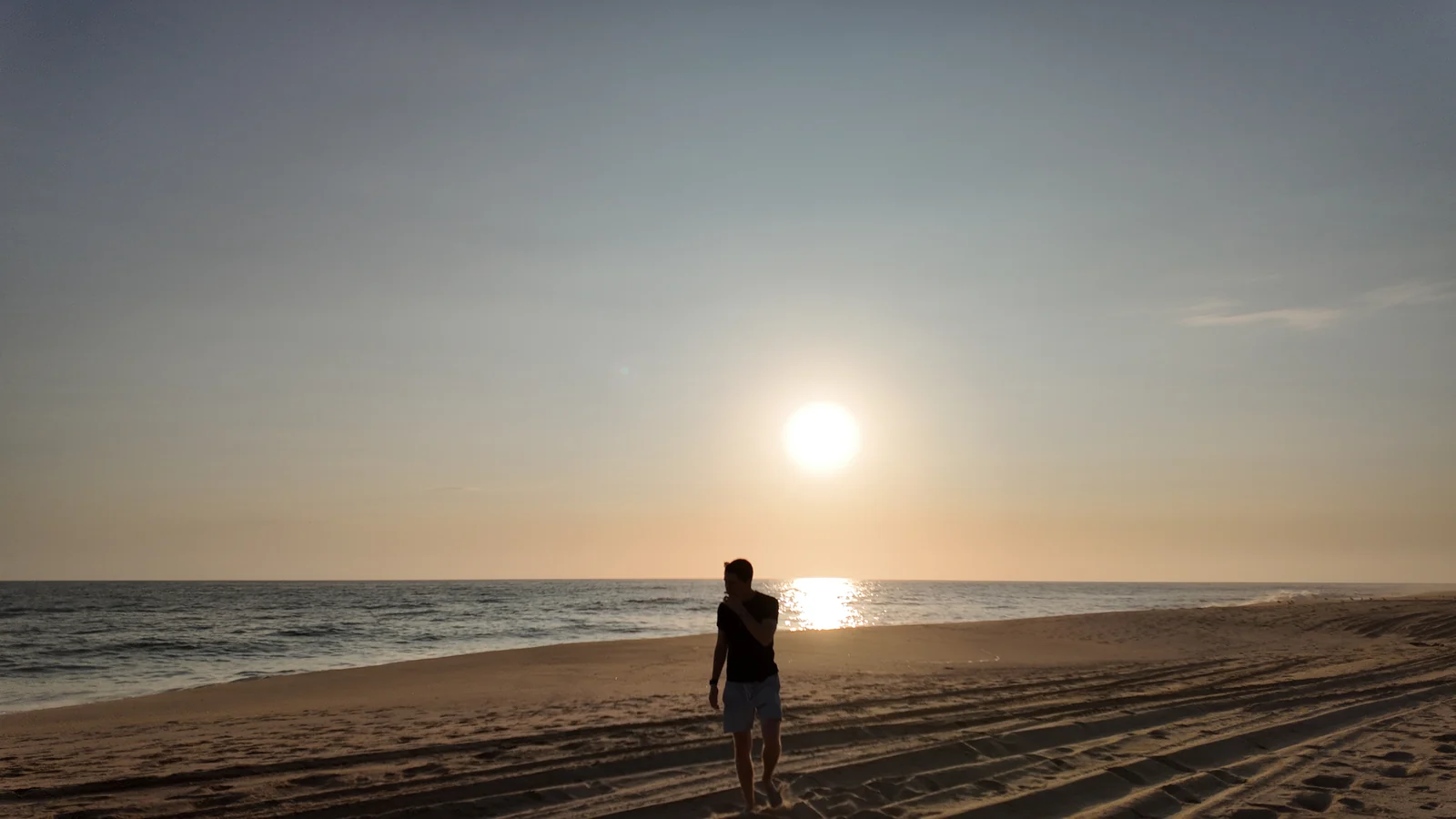 Max Ferrer walking on a beach at sunset